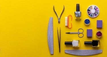 manicure and pedicure tools and accessories on yellow background top view. photo