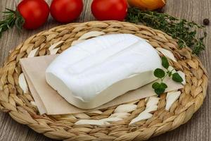 Feta cheese on wooden board and wooden background photo