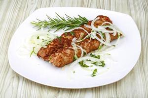 Kebab on the plate and wooden background photo