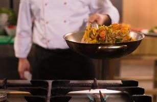 chef flipping vegetables in wok photo