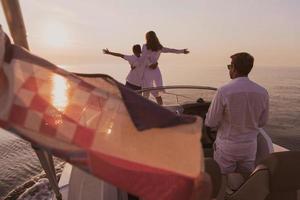 una pareja mayor con ropa informal con su hijo disfruta mientras viaja en un bote en el mar al atardecer. el concepto de una familia feliz. enfoque selectivo foto