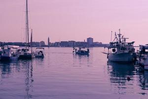 A photograph of a ship and a luxury yacht anchored in port. Beautiful photo of a Mediterranean port