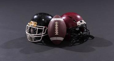 american football and helmets isolated on gray photo