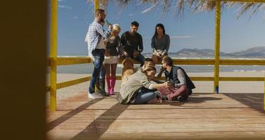 grupo de amigos divirtiéndose el día de otoño en la playa foto