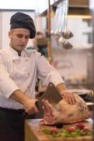 chef cutting big piece of beef photo