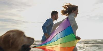 Happy couple having fun with kite on beach photo