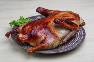 Roasted duck on the plate and wooden background photo