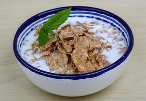 Cornfalkes desayuno en un bol sobre fondo de madera foto