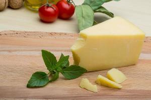 Parmesan cheese on wooden board and wooden background photo