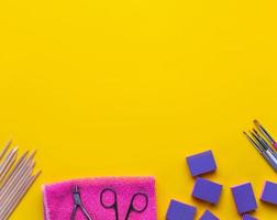 Top view of manicure and pedicure equipment on yellow background photo