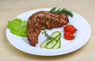Pork tenderlion on the plate and wooden background photo