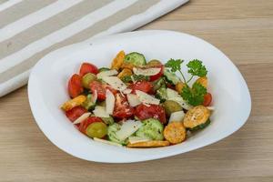 ensalada de tomate en un bol sobre fondo de madera foto