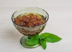 Mulberry jam in a bowl on wooden background photo