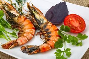 Tiger shrimps on the plate and wooden background photo