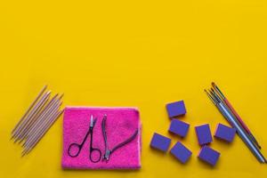 Top view of manicure and pedicure equipment on yellow background photo