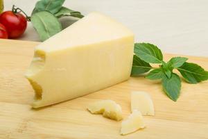 Parmesan cheese on wooden board and wooden background photo