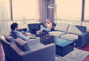 couple relaxing at  home using tablet and laptop computers photo