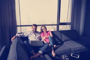 couple relaxing at  home using laptop computers photo