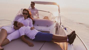 una pareja mayor con ropa informal con su hijo disfruta mientras viaja en un bote en el mar al atardecer. el concepto de una familia feliz. enfoque selectivo foto