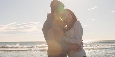 pareja divirtiéndose en un hermoso día de otoño en la playa foto