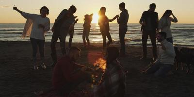 Friends having fun at beach on autumn day photo