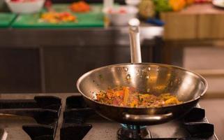 chef flipping vegetables in wok photo