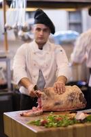 chef cutting big piece of beef photo