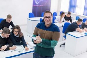 estudiante varón con otros escribiendo notas foto