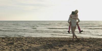 amorosa pareja joven en una playa en otoño en un día soleado foto