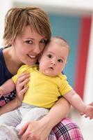 Portrait of young happy mother holding newborn baby boy photo