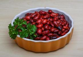 Canned beans in a bowl on wooden background photo