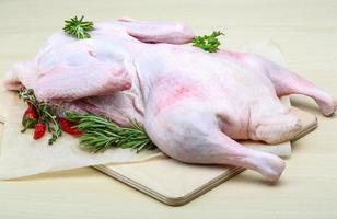 Raw duck on wooden board and wooden background photo