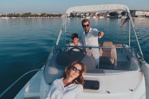 una pareja mayor con ropa informal con su hijo disfruta mientras viaja en un bote en el mar al atardecer. el concepto de una familia feliz. enfoque selectivo foto