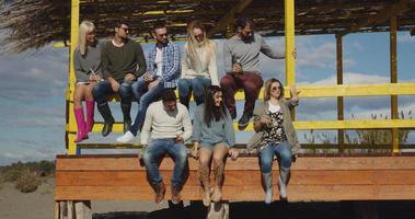 grupo de amigos divirtiéndose el día de otoño en la playa foto