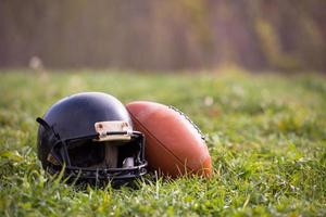 pelota y casco de futbol americano foto