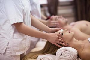 couple enjoying head massage at the spa photo