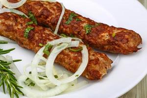 Beef kebab on the plate and wooden background photo