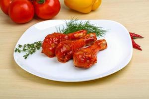 Chicken legs on the plate and wooden background photo