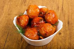 Meat balls in a bowl on wooden background photo