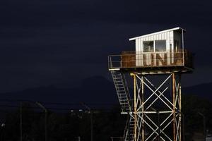 Nicosia, Cyprus, Greece - 2020 - A weathered UN guard tower illuminated by the sun with dark thunder clouds in the background. photo