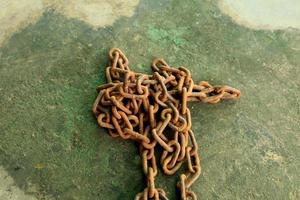 Rusty and dirty steel chains on cement floor in front of the house for locking valuable assets such as motorcycles and bicycles to prevent guerrilla theft. photo