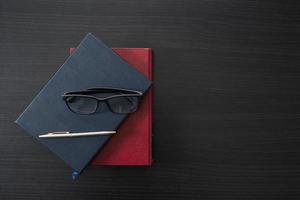 gafas y libro en el escritorio de madera foto