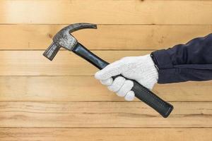 Hand in glove holding hammer photo