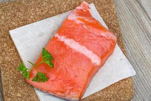 Salmon fillet on wooden board and wooden background photo