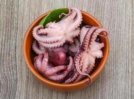 pulpo marinado en un bol sobre fondo de madera foto