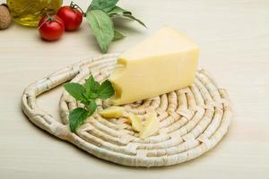 Parmesan cheese on wooden board and wooden background photo