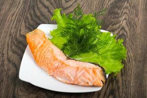 Steamed salmon on the plate and wooden background photo