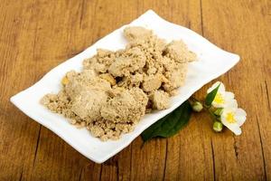 Halva on the plate and wooden background photo