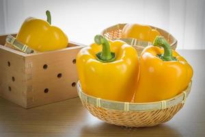 Fresh yellow bell peppers in basket photo