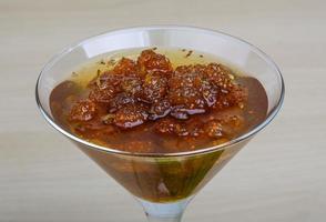 Mulberry jam in a bowl on wooden background photo